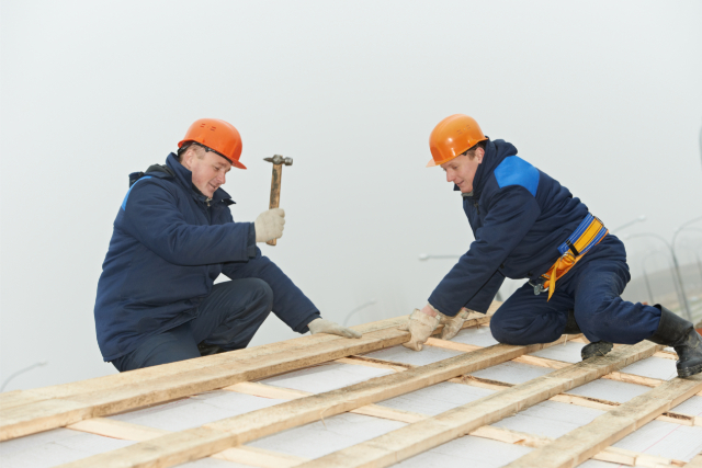 Roofing Workers repairing a roof with a hammer